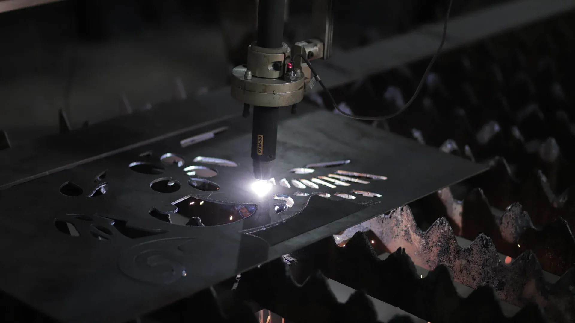 Close-up of a plasma cutting machine working on a metal sheet in an industrial setting
