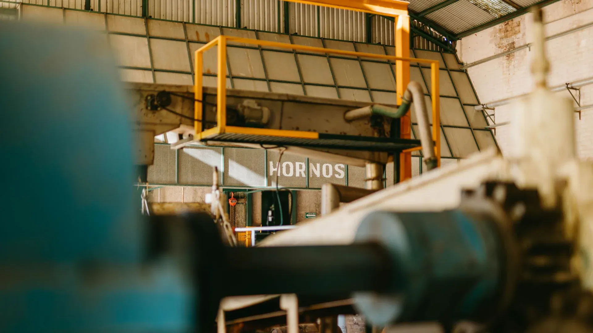 Close-up of heavy machinery inside an industrial factory with focus on ironworks and conveyor systems