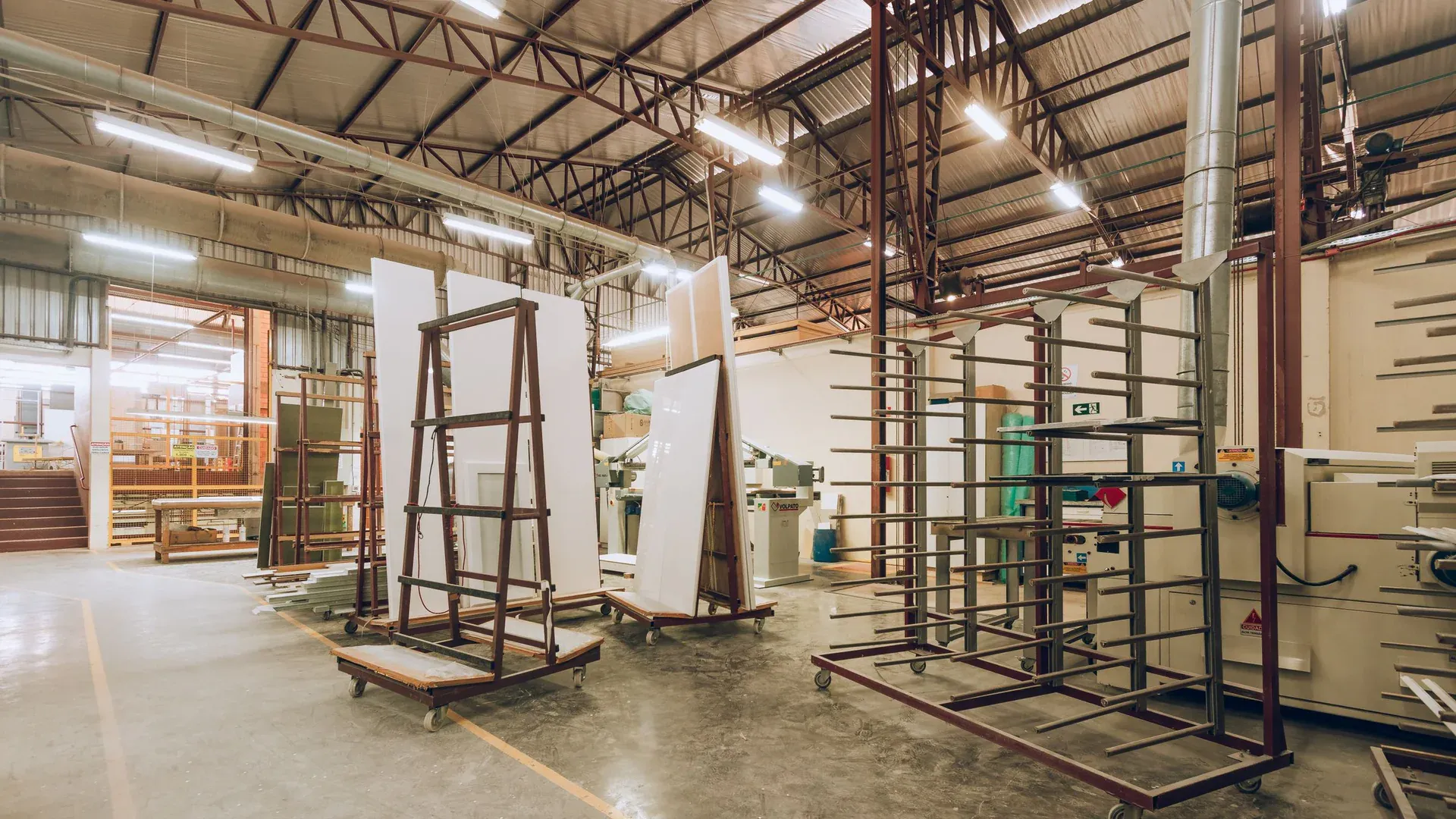 A large, well-lit industrial factory interior showcasing machinery and storage solutions