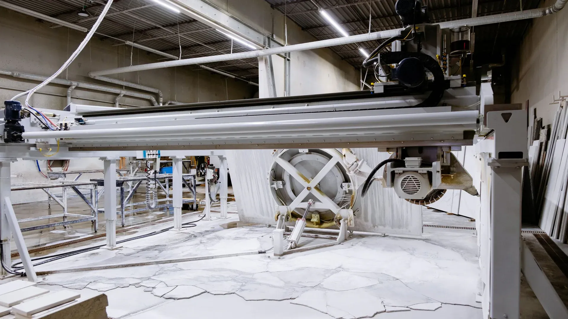 Modern industrial setting with a large granite cutting machine in action inside a factory
