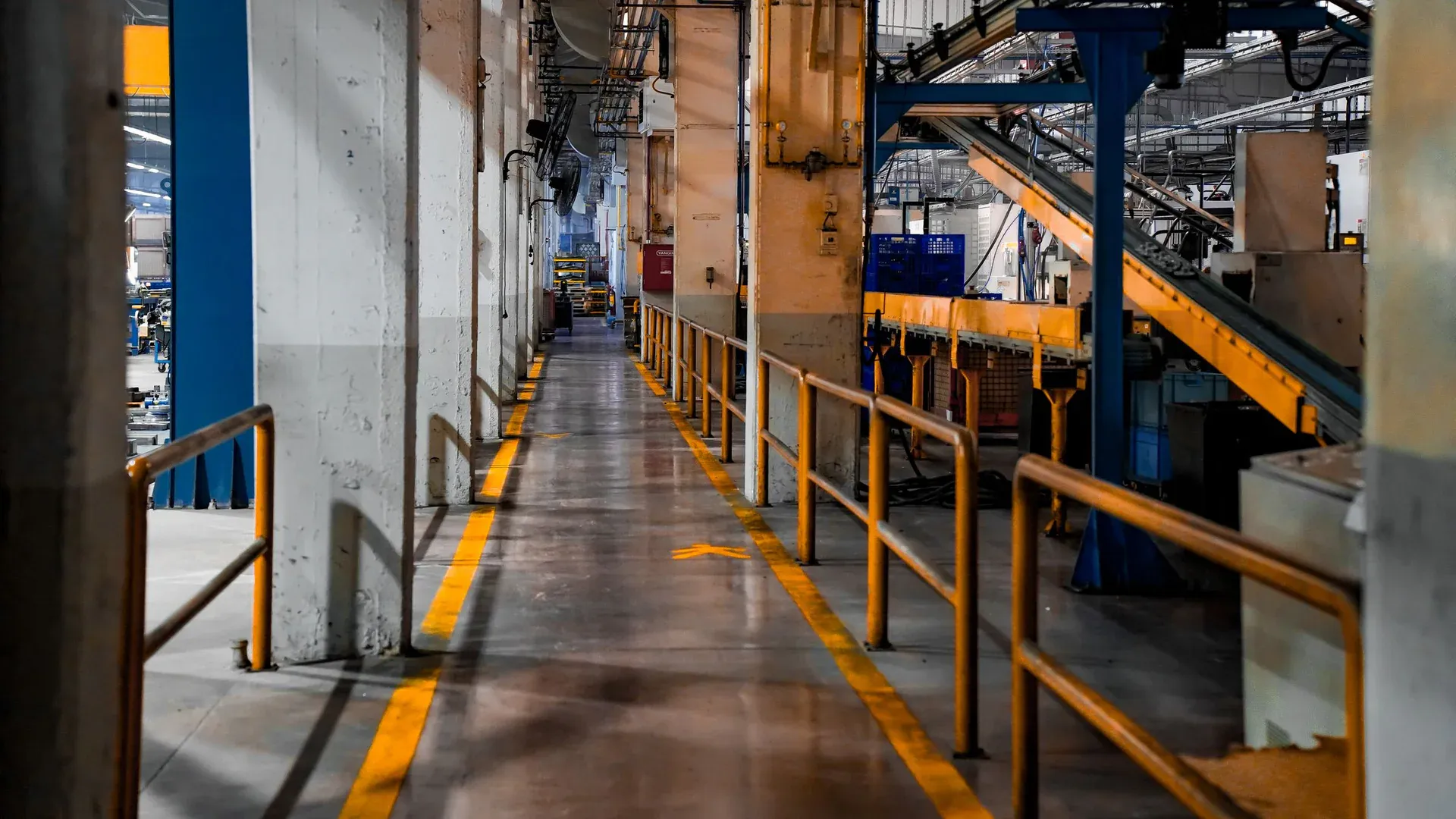Wide view of a modern factory interior showcasing industrial machinery and conveyor systems