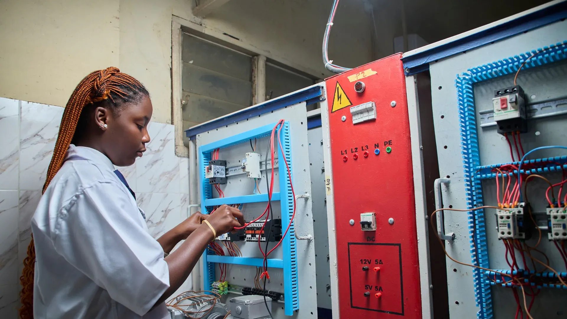 Technician inspecting an industrial machine electrical control cabinet