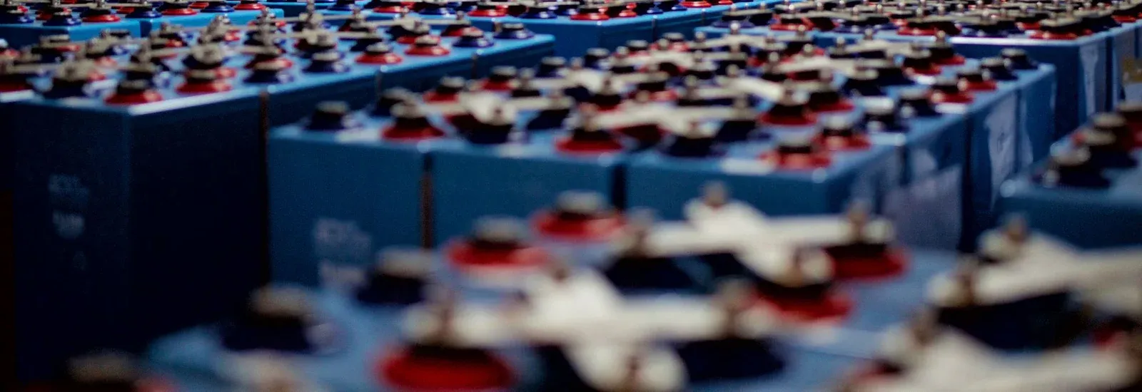 Rows of industrial battery containers with terminals and connecting leads