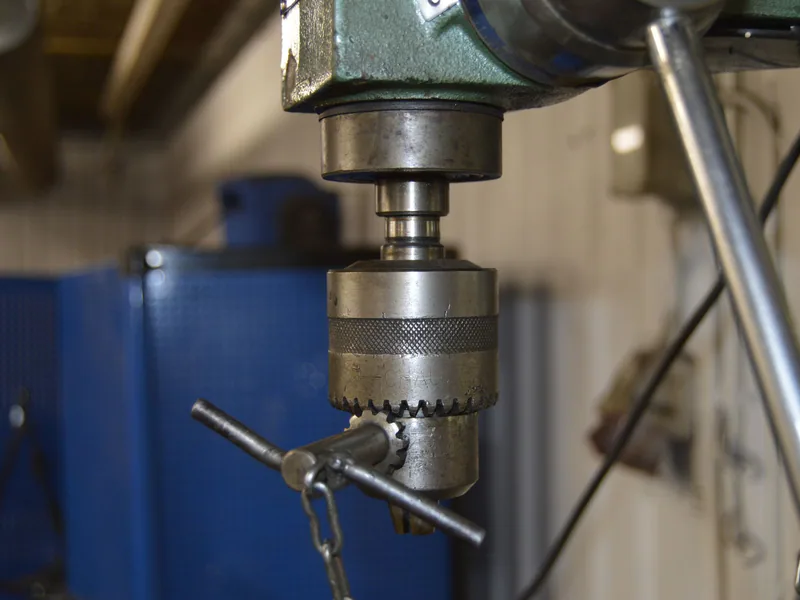 Close-up of a drill press in a Swedish workshop, showcasing industrial machinery