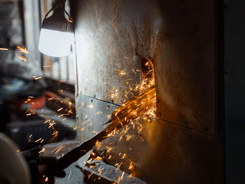 Detailed image of metal grinding with flying sparks in a workshop setting