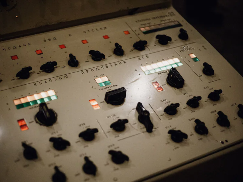 Close-up of an old-fashioned control panel with illuminated buttons and Russian text