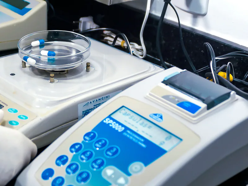 Close-up of laboratory equipment with capsules, capturing pharmaceutical analysis