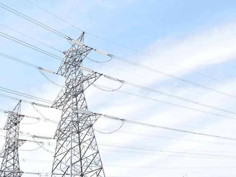 Steel transmission towers against blue sky, highlighting energy and electricity infrastructure