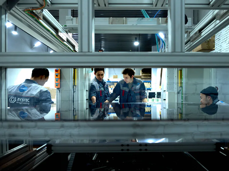 Engineers collaborate over advanced machinery in a high-tech indoor workspace