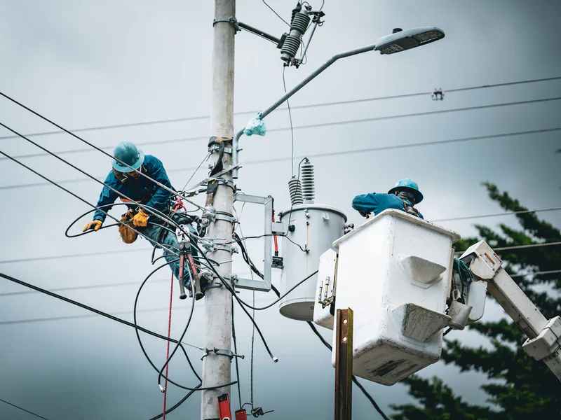 Electricians in San José, Costa Rica, repairing power lines from a cherry picker