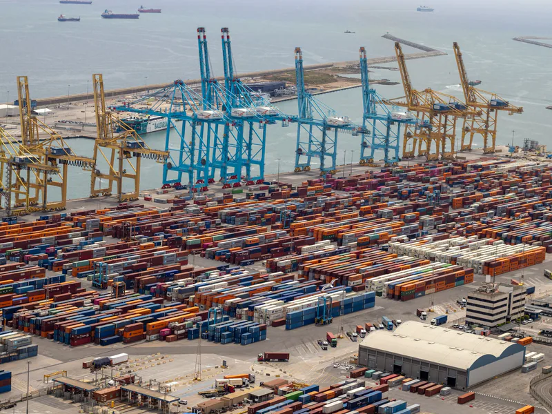 A bustling port with shipping containers and cranes, showcasing global trade