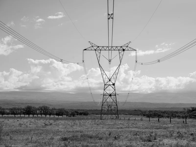 A black and white view of an electricity transmission tower in a vast landscape in Córdoba, Argentina
