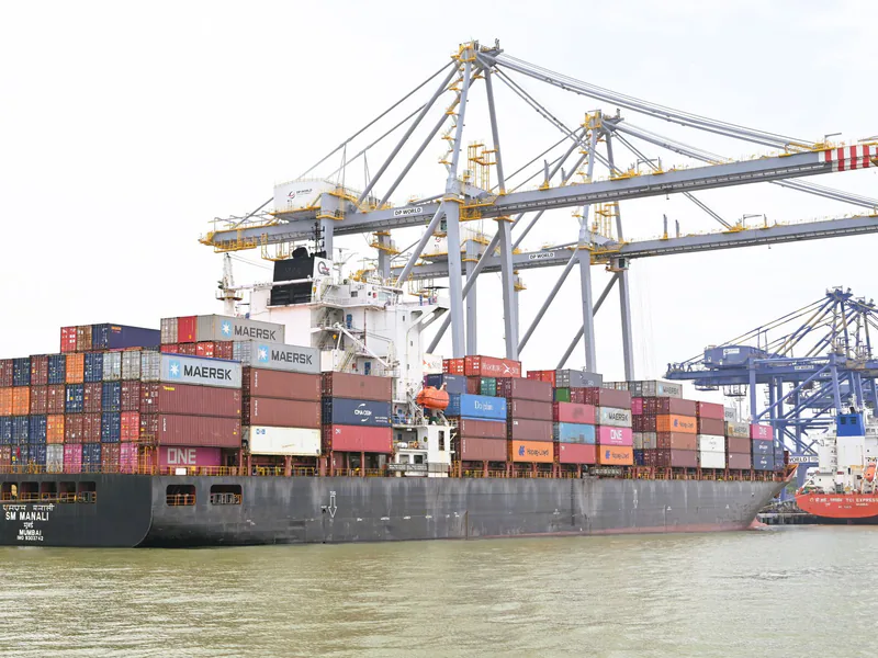 Cargo vessel moored at Kochi, Kerala, India, showcasing global container shipping with cranes in background