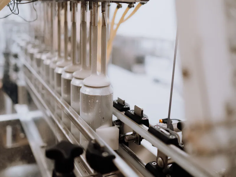 Close-up of automated canning equipment in a brewery, highlighting the manufacturing process