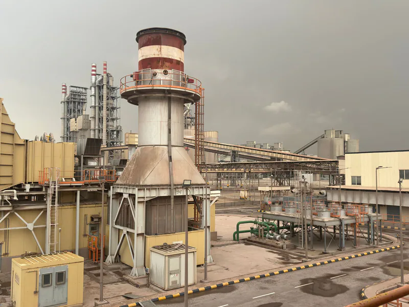 A large industrial facility on a cloudy day in Saudi Arabia, showcasing structures and machinery
