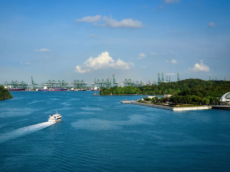 Stunning aerial view of Singapore’s bustling harbor and green cranes against a clear blue sky