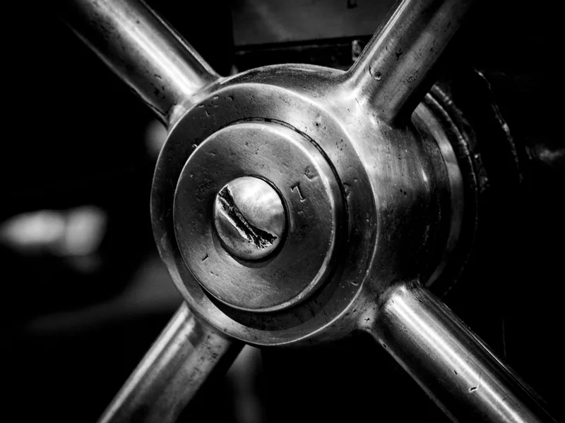 Detailed black and white image of an industrial metal cog showcasing intricate machinery design