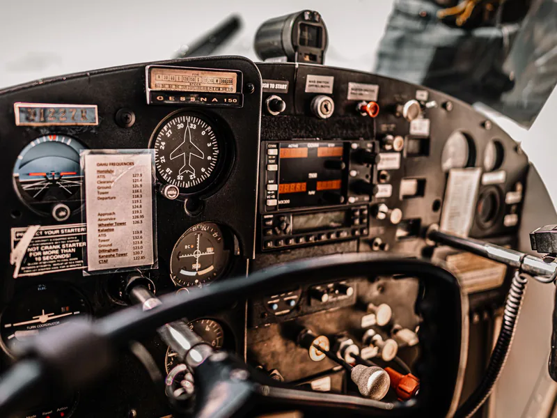 Control dashboard and yokes in cockpit of small light airplane parked in airfield