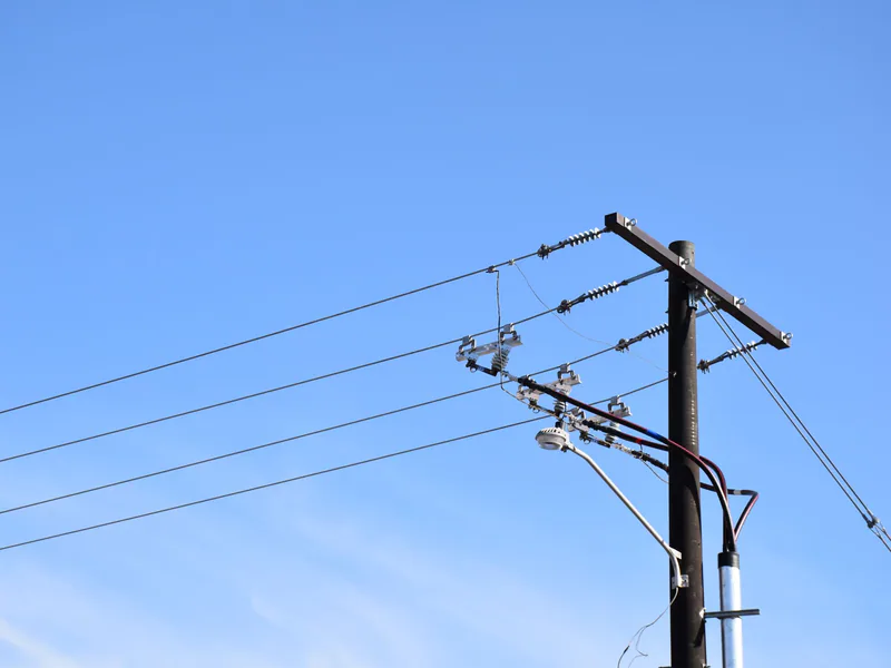 Low angle view of power lines and pole against a blue sky in Logan, Utah