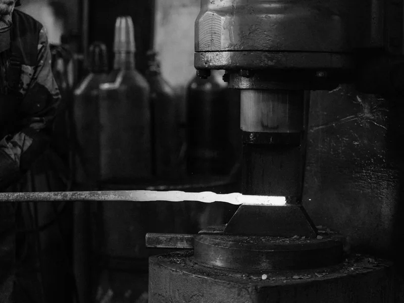 Monochrome image of a blacksmith’s forge with metal being processed
