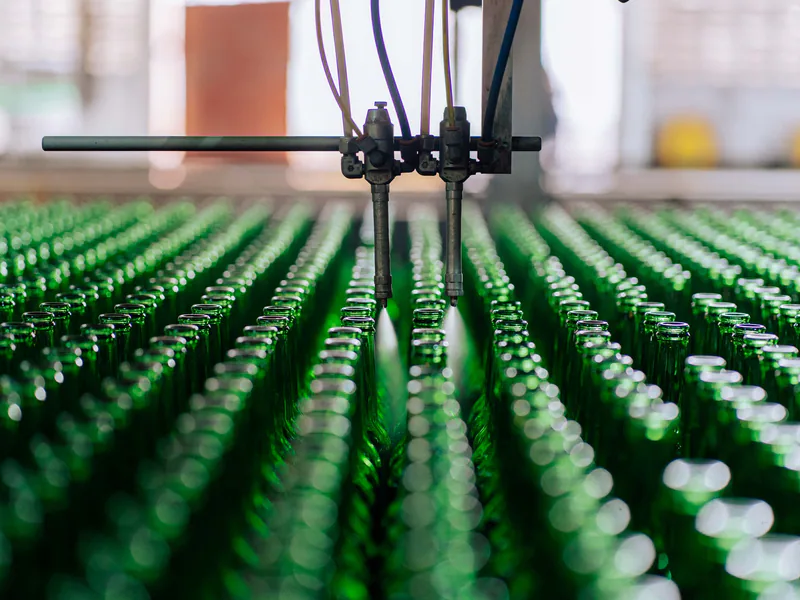 Glass bottles on an automated line in a factory, showcasing industrial glass making
