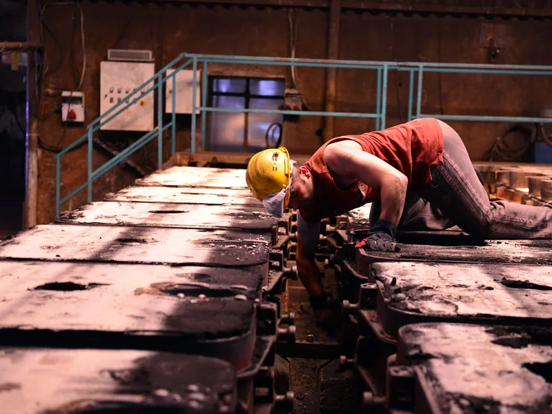 Worker inspecting metal billets during a nondestructive test