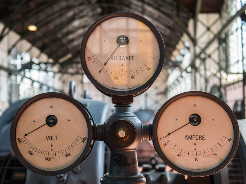 Analog gauges showing voltage, current, and power readings