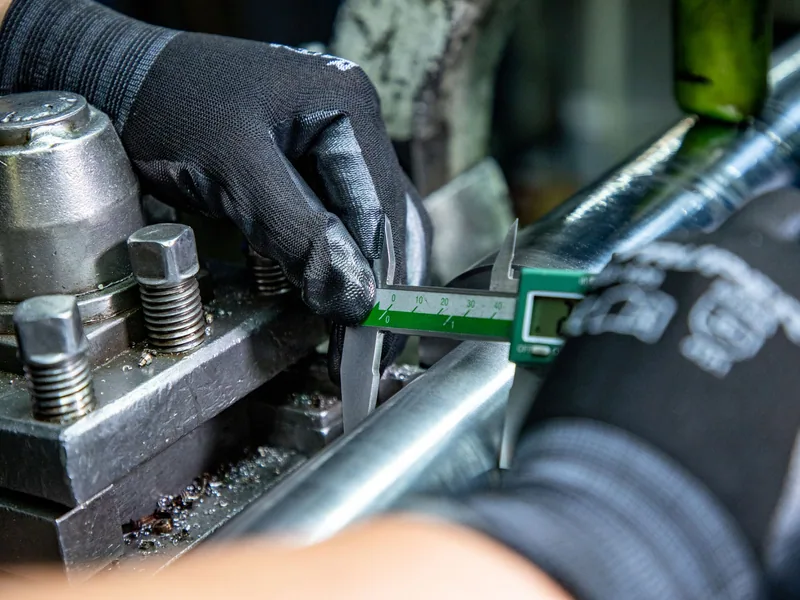 Digital caliper used to inspect a first production component