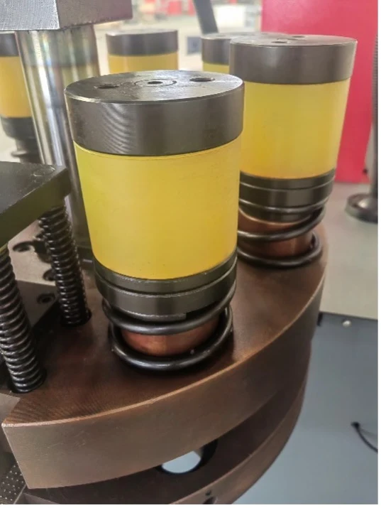Close-up view of a busbar turret punching station with circular punch dies installed