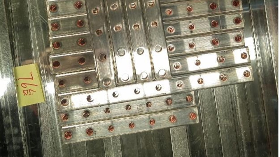 Bent copper busbar samples showing material behavior after CNC forming